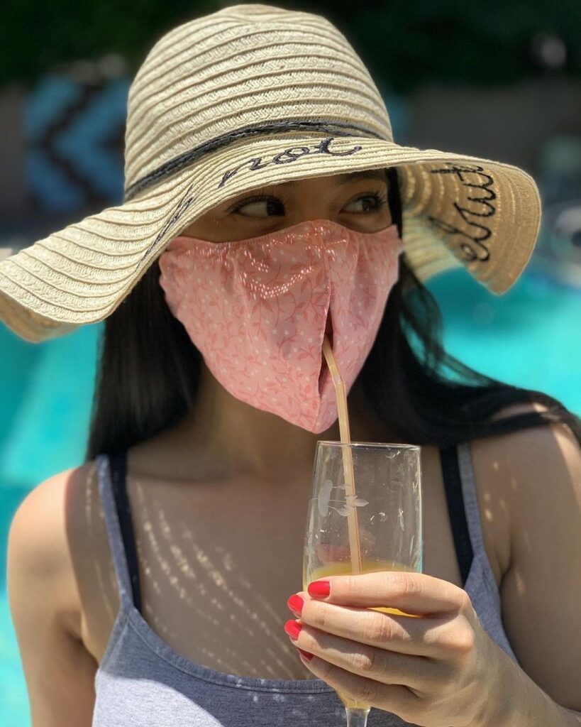 Woman wearing a mask with a slit for a straw